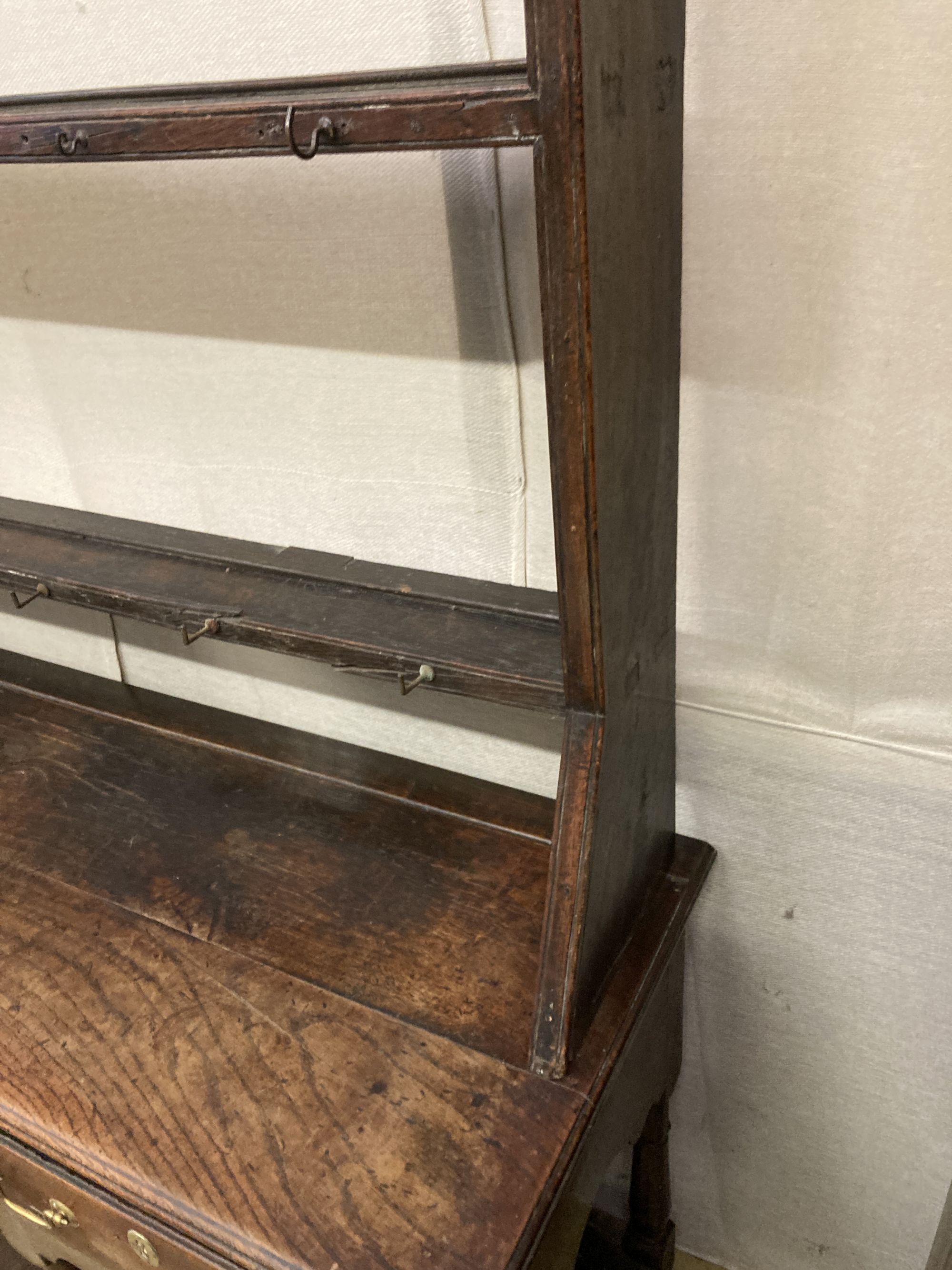 An 18th century oak potboard low dresser with associated rack, length 152cm, depth 48cm, height 193cm